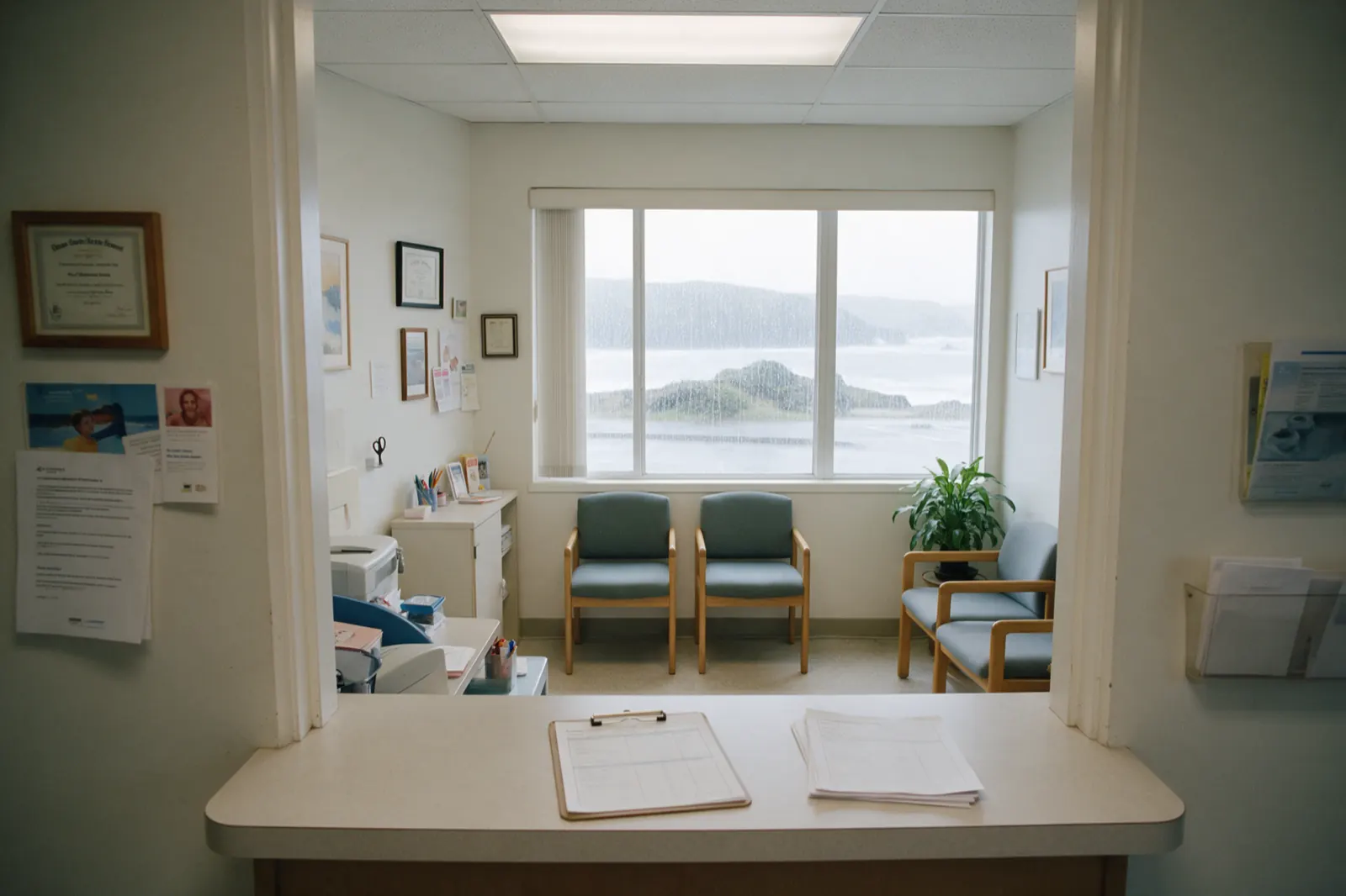 The reception desk stands empty between appointments, a sign-in clipboard squared on the counter and a stack of blank forms beside it.